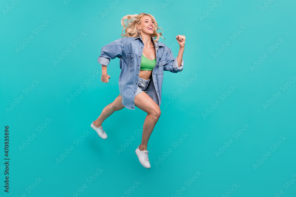 Full size photo of happy cheerful positive woman jump up run empty space isolated on blue color background