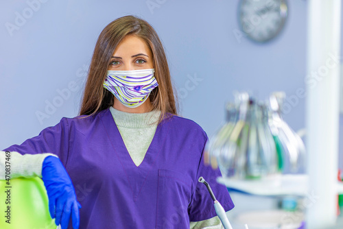 Young female dentist holding dental tools in her clinic