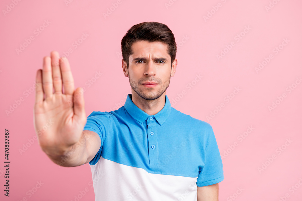 Photo of young serious cool male showing stop no gesture warning you prohibition isolated on pink color background Photo of young serious cool male showing stop no gesture warning you prohibition isolated on pink color background