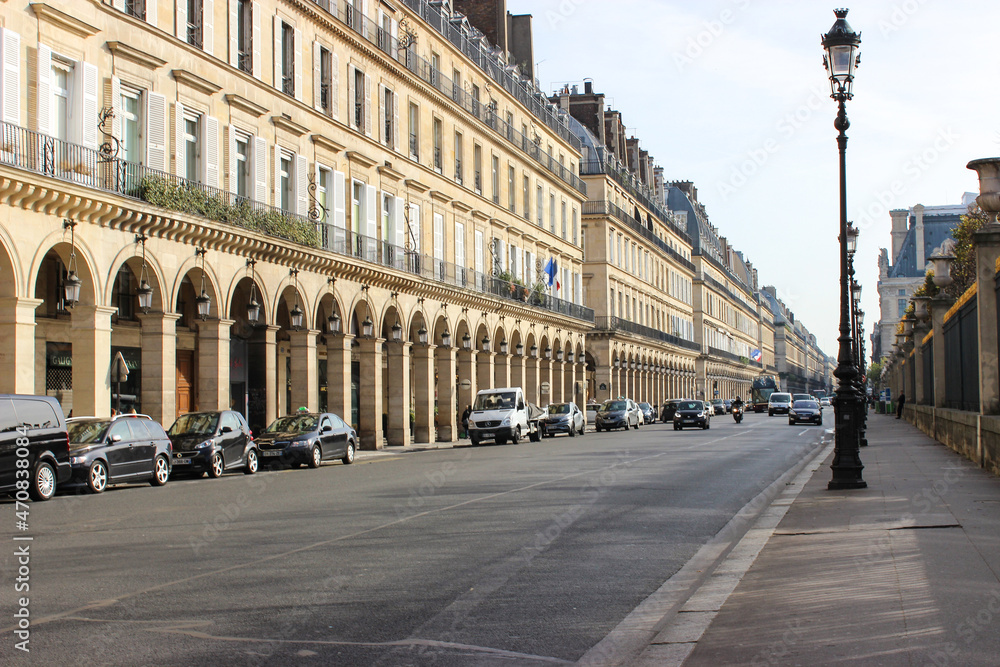 Cozy small streets of Paris. Everyday life. Beige buildings with several floors. Roads with cars, bicycles. French life.