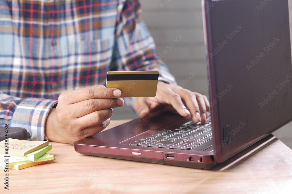 man hands holding credit card and using laptop shopping online 