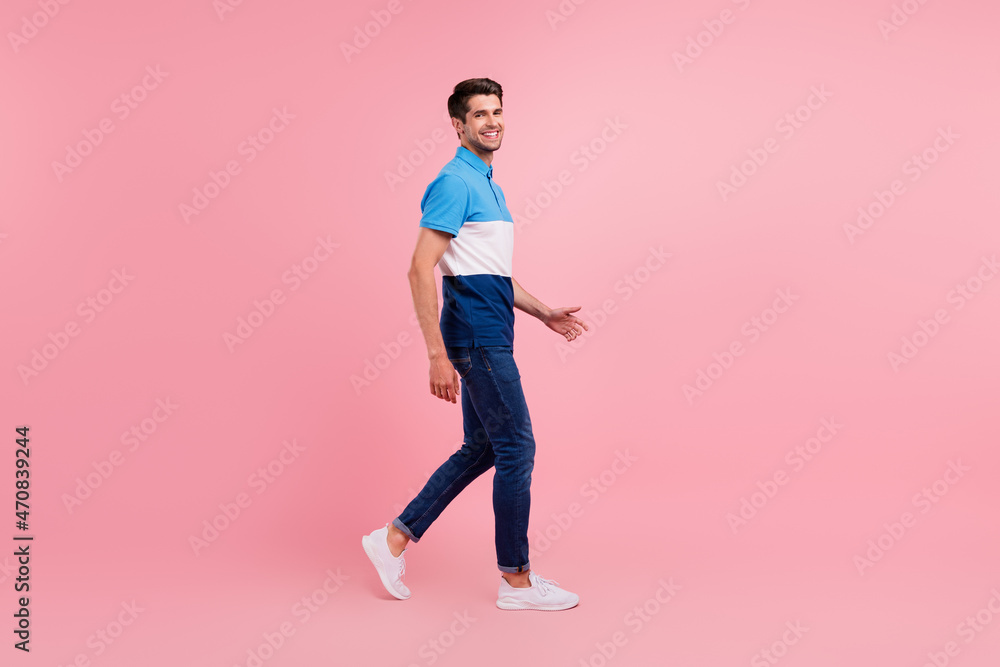 Full length profile photo of nice brunet young guy go wear polo jeans sneakers isolated on pink background Full length profile photo of nice brunet young guy go wear polo jeans sneakers isolated on pink background
