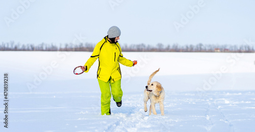 Girl with cute young retriever dog on winter walk