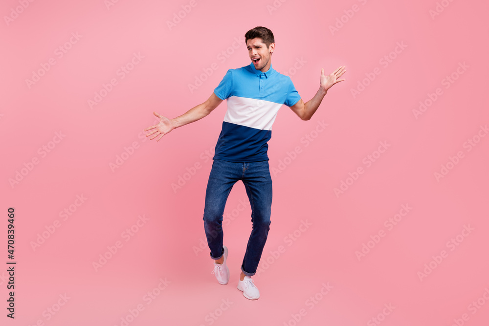 Full size photo of funky brunet young guy dance wear polo jeans sneakers isolated on pink background Full size photo of funky brunet young guy dance wear polo jeans sneakers isolated on pink background