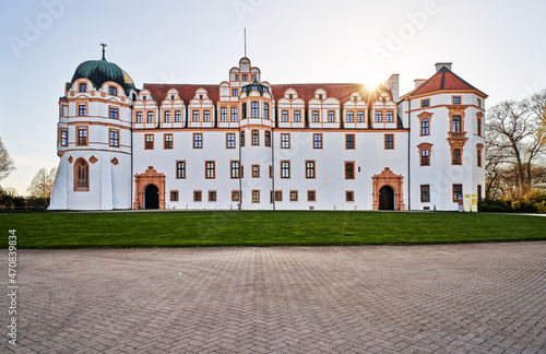 Celle, Germany - April 24, 2021: the freshly painted residence palace in front of a bright sun with sunbeams