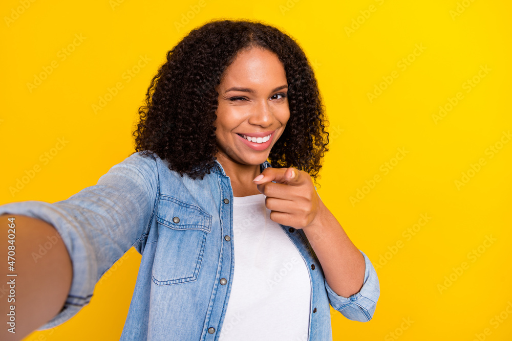 Photo of young happy afro american cool woman wink point finger you make selfie isolated on yellow color background