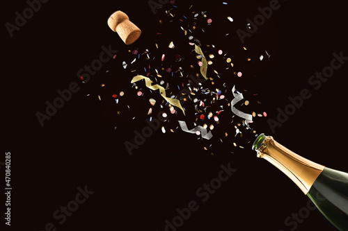 Картината върху платно Freshly opened bottle with confetti and ribbons coming out isolated