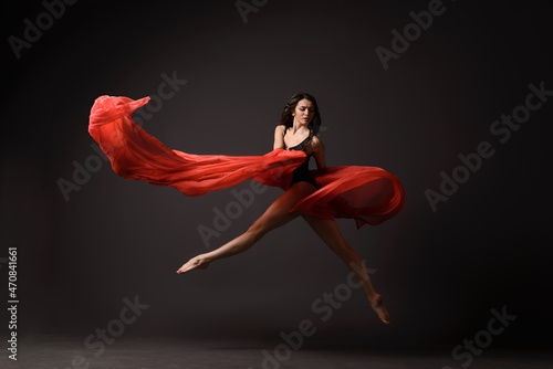 Ballerina jumping with red cloth