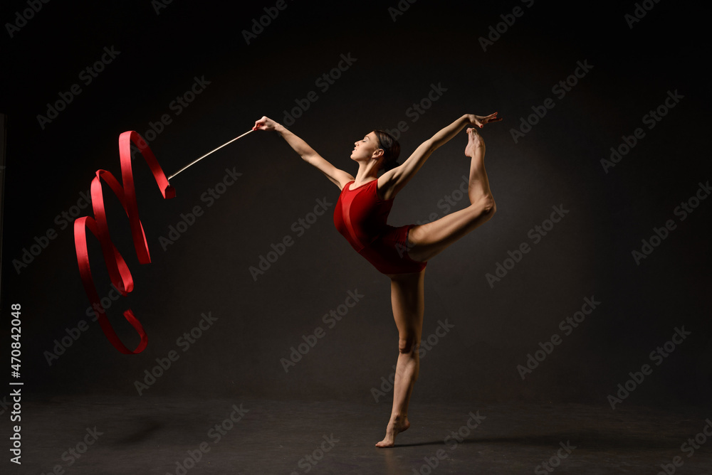 Gymnast with red ribbon on gray background