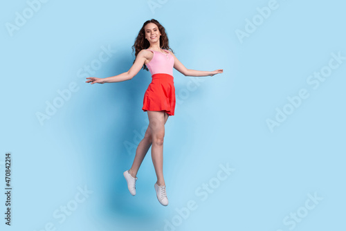 Fototapeta Naklejka Na Ścianę i Meble -  Full body profile side photo of young excited girl have fun jump up air isolated over blue color background
