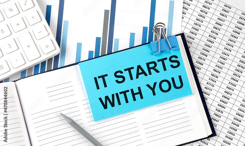IT START WITH YOU text on blue sticker on the chart background near calculator IT START WITH YOU text on blue sticker on the chart background near calculator