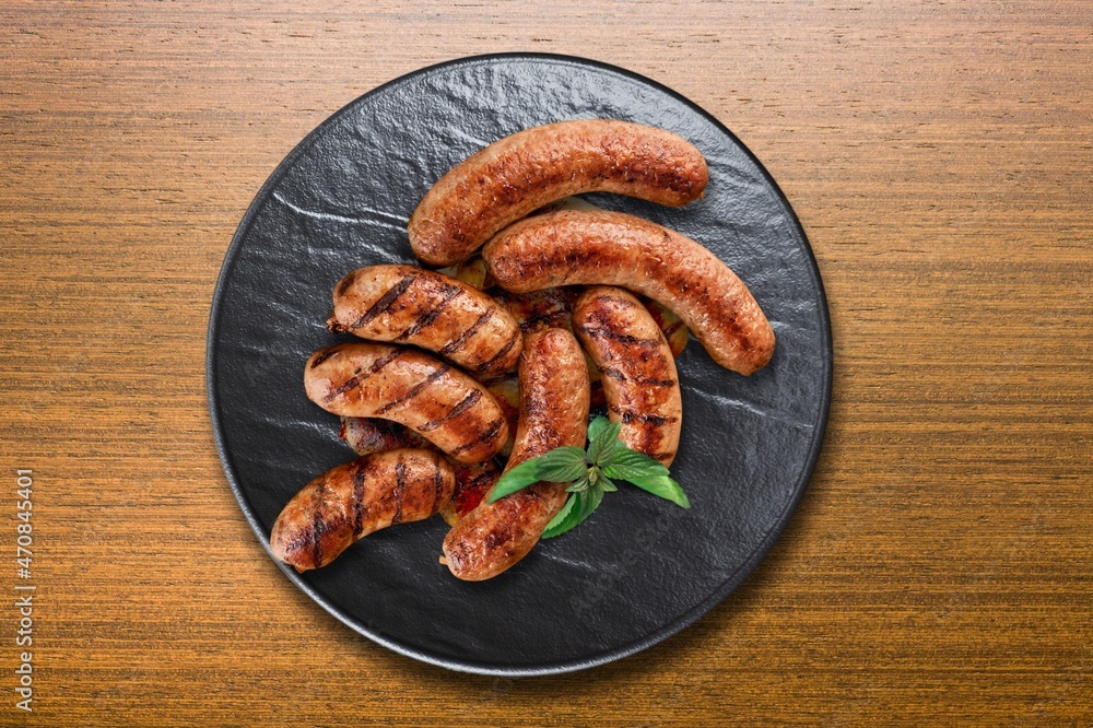 A plate of fried sausages with garlic and basil