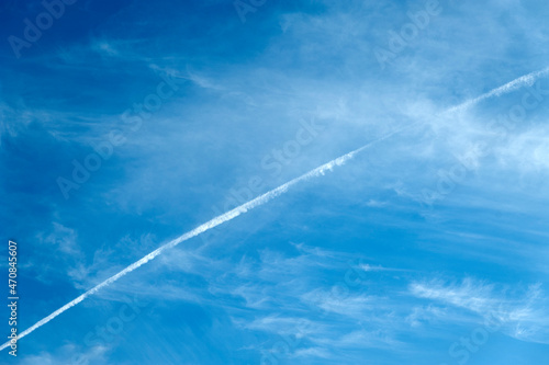 Airplane smoke in cloudy blue sky.Stock photo.