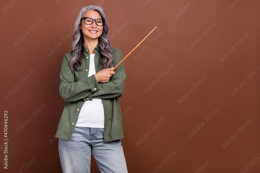 Photo of funny elder white hairdo lady index empty space wear shirt eyesight jeans isolated on brown color background Photo of funny elder white hairdo lady index empty space wear shirt eyesight jeans isolated on brown color background