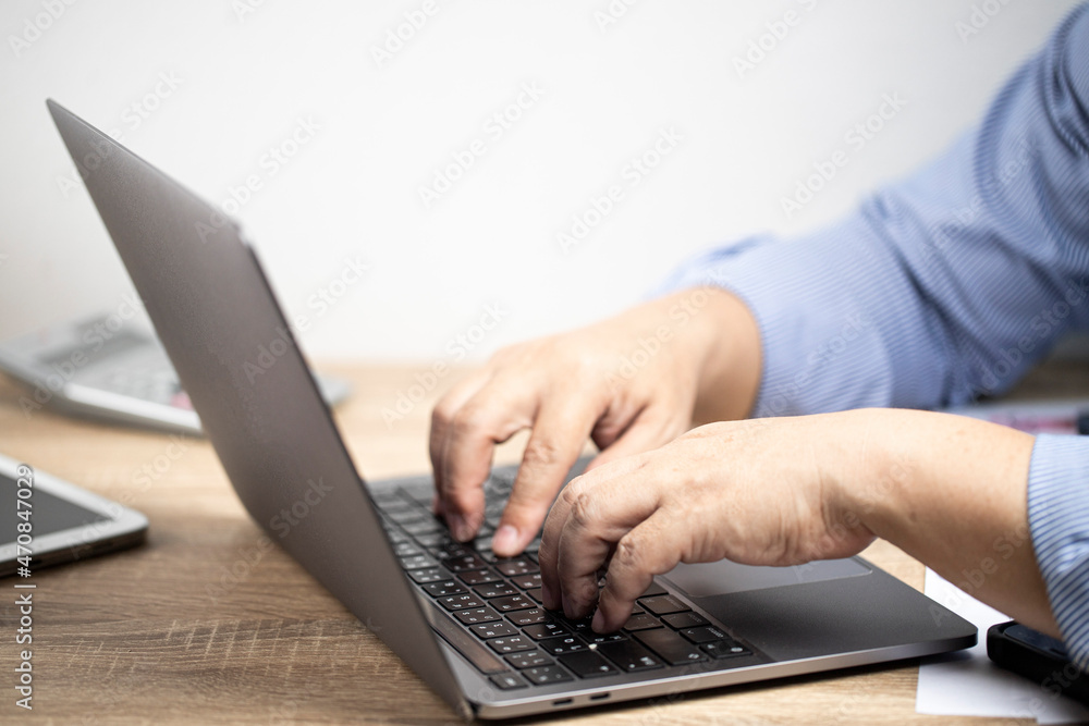 Men places his hands on the notebook, over the brown table and white background Men places his hands on the notebook, over the brown table and white background