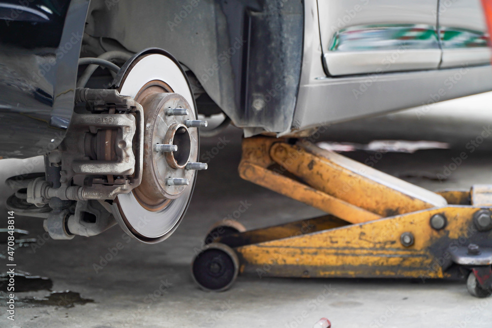 Disc brake of the vehicle for repair,Seal a leaking car tire.Car brake repairing in garage.Dirty