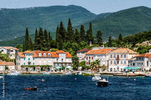 Scenic Mediterranean city in Montenegro with mountains, view from Adriatic sea. Beautiful architecture with orange roofs