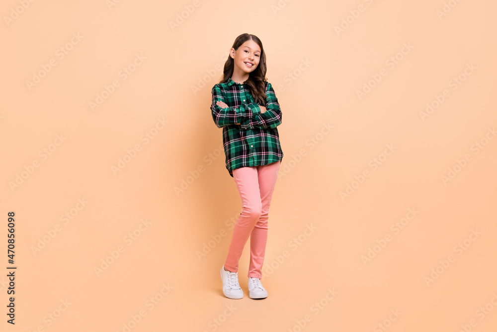 Photo of funky cool schoolgirl wear plaid outfit dancing arms crossed smiling isolated beige color background Photo of funky cool schoolgirl wear plaid outfit dancing arms crossed smiling isolated beige color background