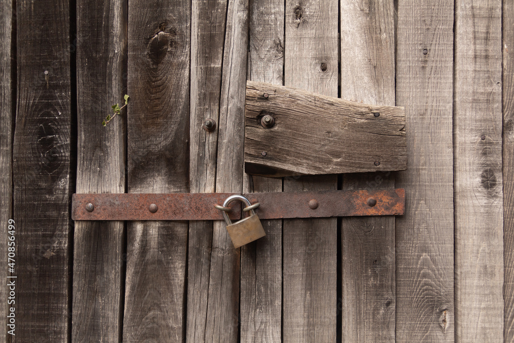 Old wooden door background with metal. Abstract old wood texture.Closed door, padlock, threshold, rust and roots. Old wooden door background with metal. Abstract old wood texture.Closed door, padlock, threshold, rust and roots.