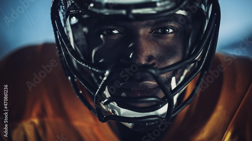 American Football: Close-up of Professional African-American Player Looking at Camera. Hero Athlete Ready to Win the Championship. Determination, Skill, Power. Dramatic Portrait Shot photo