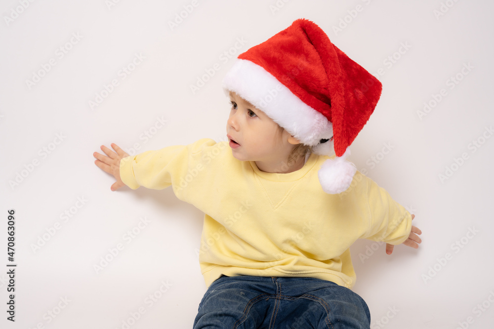 Cute little boy wearing santa hat isolated over white background. Cute little boy wearing santa hat isolated over white background.