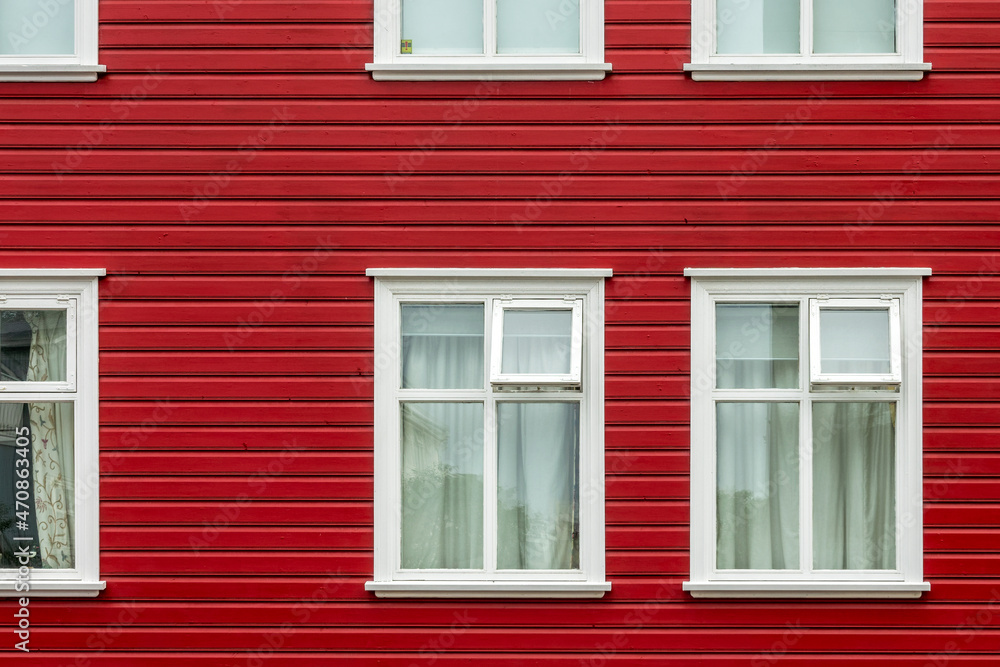 Windows on a red painted wall, colorful house, architecture detail in Reykjavik, Iceland Windows on a red painted wall, colorful house, architecture detail in Reykjavik, Iceland