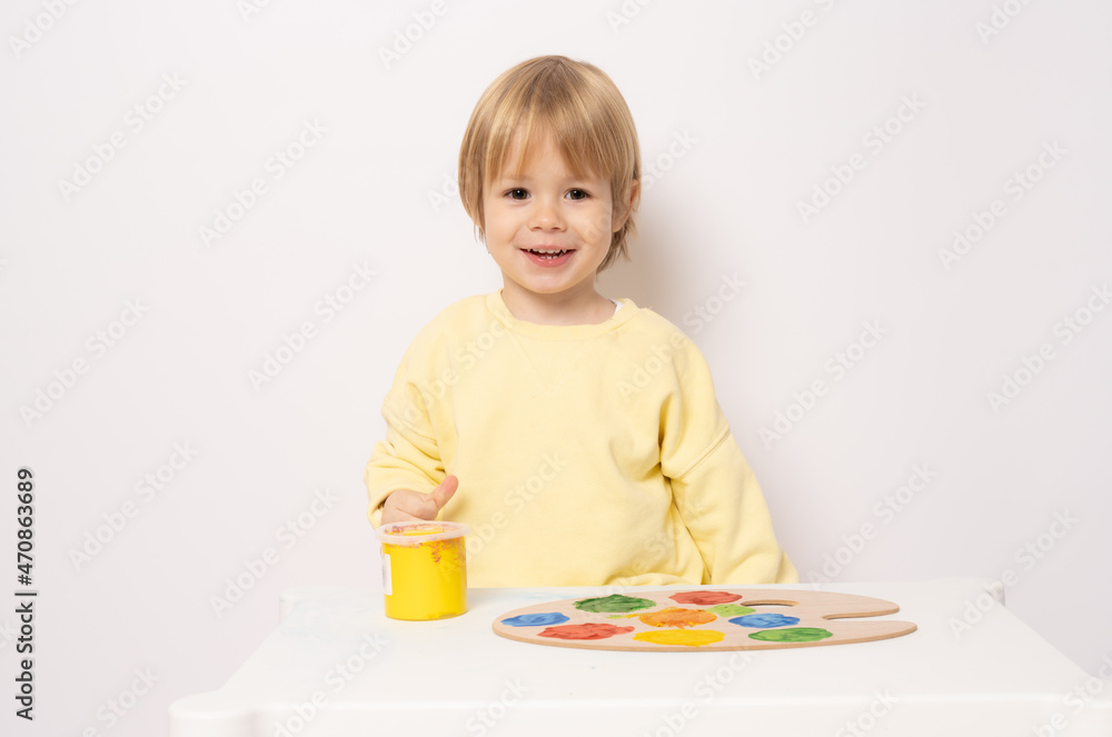 Happy little boy at the table drawing isolated on white Happy little boy at the table drawing isolated on white