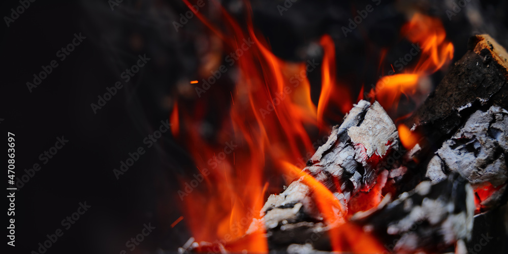 Bonfire flame with burning wood and embers. Fire with smoke and sparks. Close-up with copy space. Bonfire flame with burning wood and embers. Fire with smoke and sparks. Close-up with copy space.