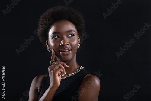 Close up portrait of african american woman with afro hairstyle on black studio background