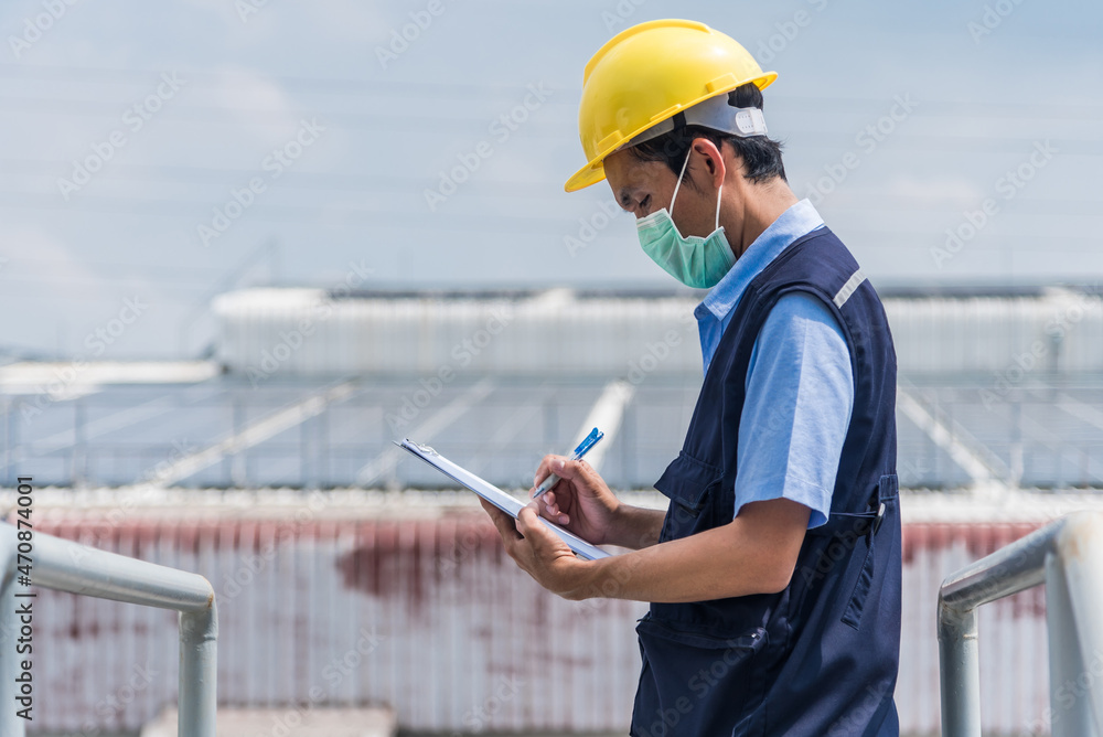 Worker with clipboard at factory building background Worker with clipboard at factory building background