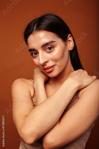 cute happy young indian woman in studio closeup smiling on brown background  fashion beauty lifestyle people concept