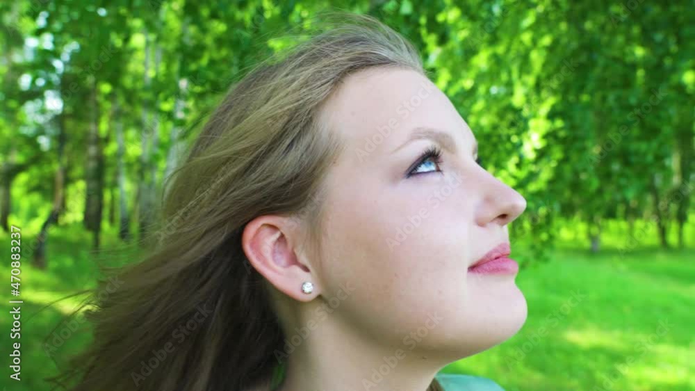 A beautiful girl looks up into the sky and dreams. In the woods in summer. A beautiful girl looks up into the sky and dreams. In the woods in summer.