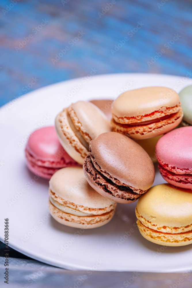 Stacked macarons of different flavors on a plate.