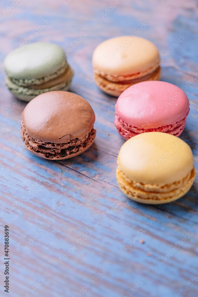 Stacked macarons of different flavors on an old wooden table. Stacked macarons of different flavors on an old wooden table.