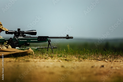 Obraz na plátne a sniper shoots lying down with a rifle with an optical sight