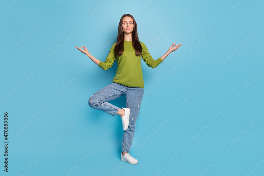 Leinwandbild Motiv - deagreez : Photo of peaceful serene calm lady enjoy meditation practice wear green shirt jeans isolated blue color background