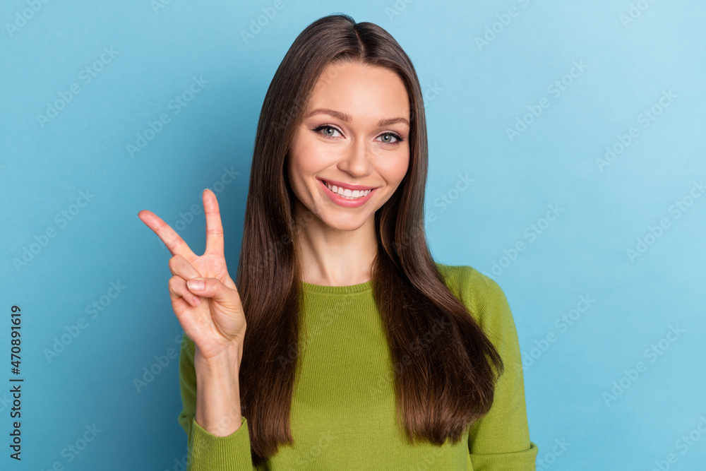 Photo of young lovely lady good mood show fingers peace cool v-symbol isolated over blue color background Photo of young lovely lady good mood show fingers peace cool v-symbol isolated over blue color background