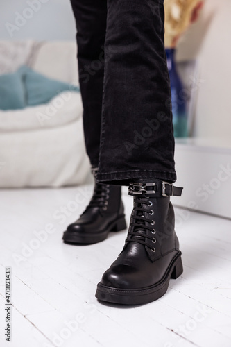 New collection of women's shoes fall-winter 2022. Women's legs in black leather boots.
