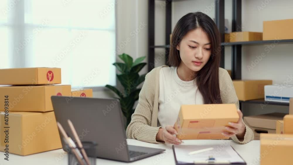 Young asian entrepreneur woman checking product on stock take note with laptop. Business woman working SME online at home. Check address on parcel. Small business owner start up freelance concept. Young asian entrepreneur woman checking product on stock take note with laptop. Business woman working SME online at home. Check address on parcel. Small business owner start up freelance concept.