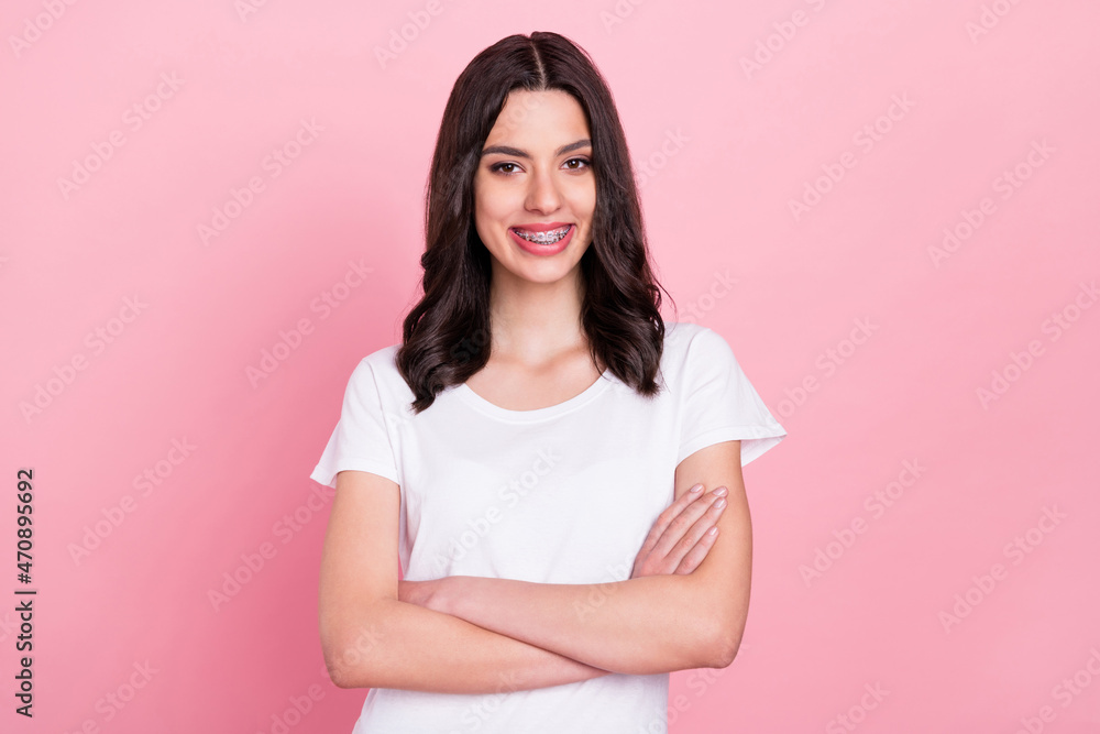 Photo of cheerful young charming woman hold hands crossed smile good mood isolated on pink color background Photo of cheerful young charming woman hold hands crossed smile good mood isolated on pink color background