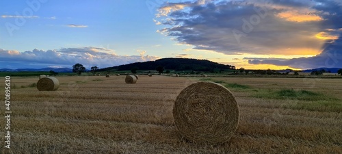 Hay bales against the backdrop of colourful sunset clouds, France