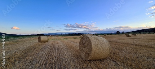 Hay bales against the backdrop of colourful sunset clouds, France