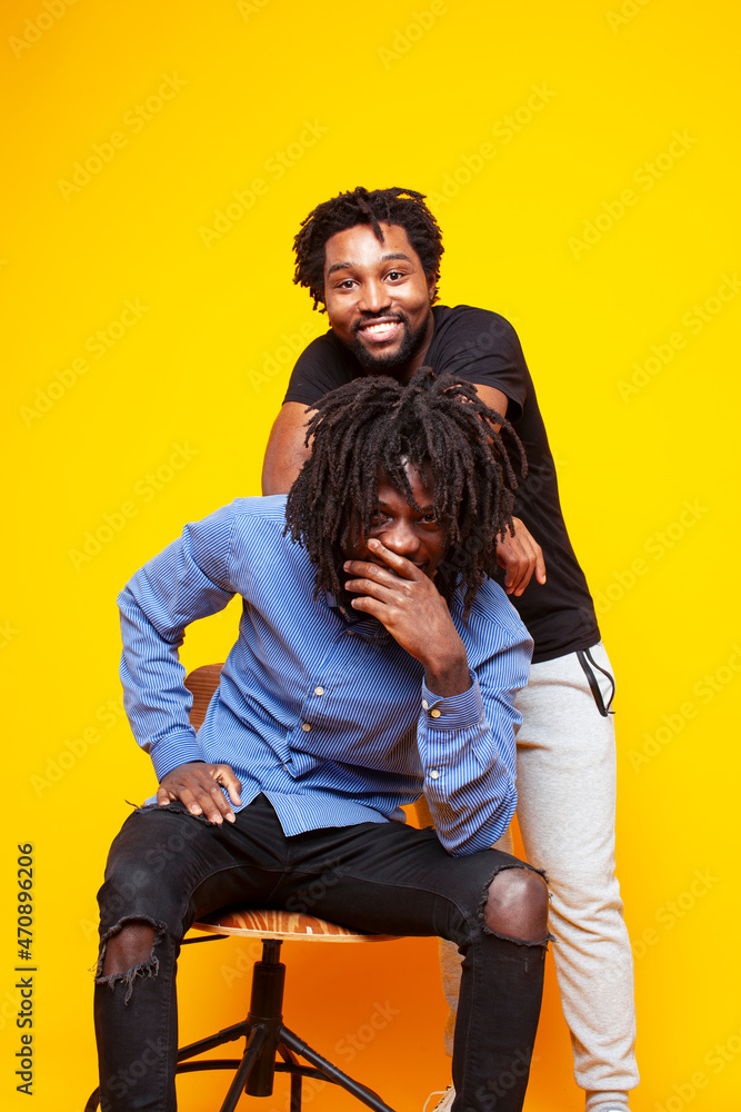two african american guys posing cheerful together on yellow background, lifestyle people concept two african american guys posing cheerful together on yellow background, lifestyle people concept