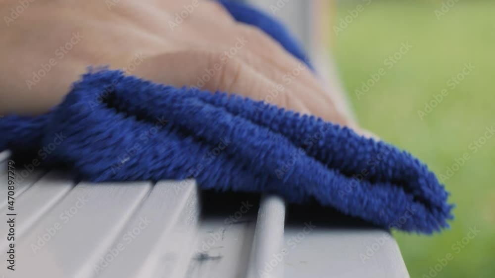Hand wiping dust by blue microfiber cloth for cleaning on the glass window rail. Hand wiping dust by blue microfiber cloth for cleaning on the glass window rail.