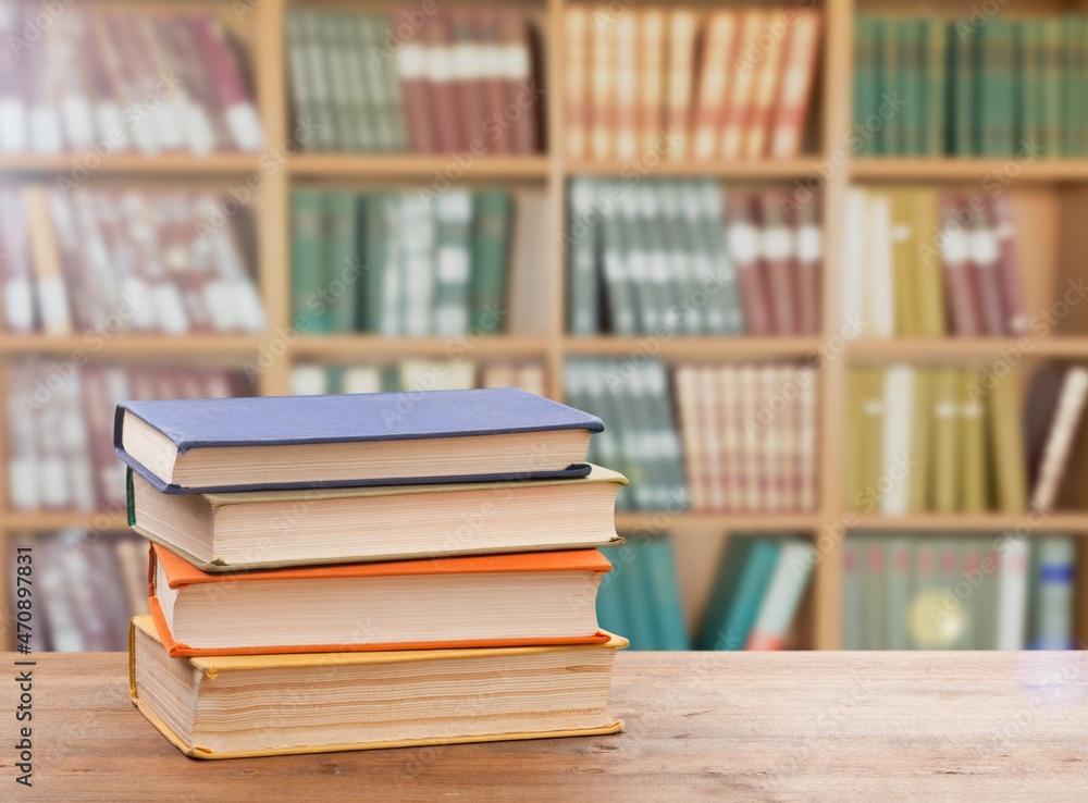 Stack of books on the table in the library background Stack of books on the table in the library background