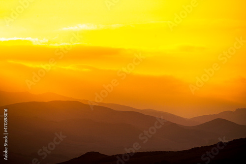 Fototapeta Naklejka Na Ścianę i Meble -  Yellow sunset in the layers of mountains