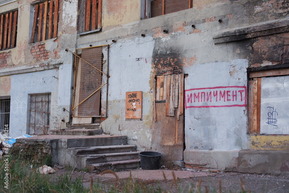 An ugly old house before redevelopment with «impeachment» graffito just before the entry