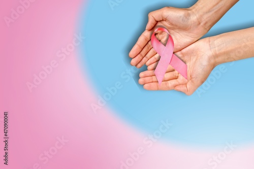 Hand with pink ribbon on background. Breast cancer awareness concept