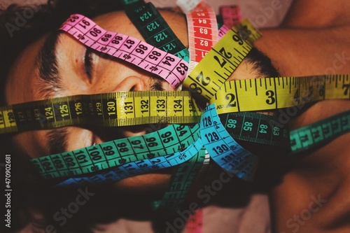 abstract art portrait of young man with measuring tapes through mouth on body dysmorphia, self image, height