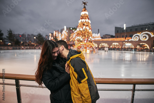 young couple in the winter park. concept of young family spending winter holidays together